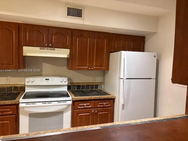 a kitchen with a refrigerator sink stove and cabinets