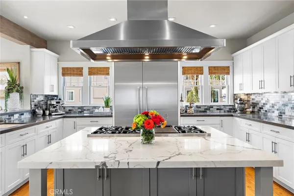a kitchen with a stove a refrigerator and a dining table with wooden floor