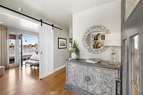 a living room with stainless steel appliances granite countertop furniture and a wooden floor