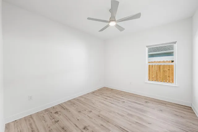 an empty room with a window and wooden floor