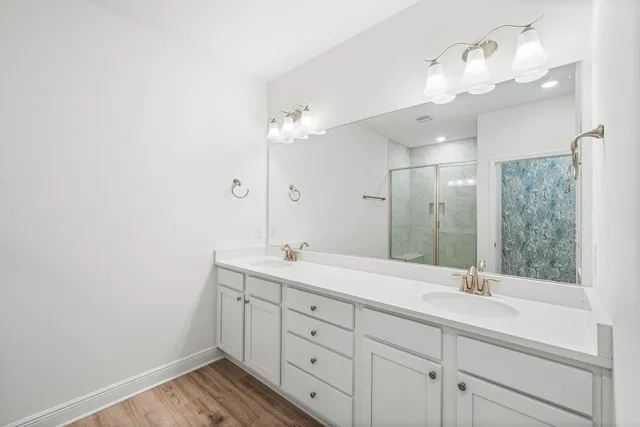 a spacious bathroom with a granite countertop sink a mirror and shower