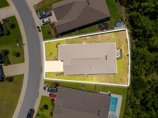 an aerial view of a house with a garden and lake view