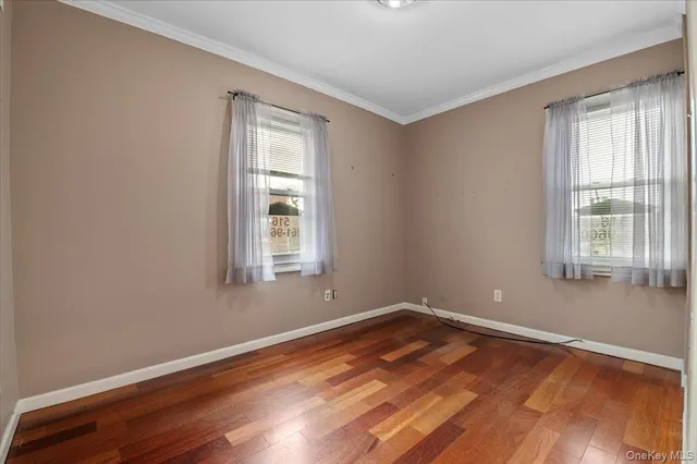 a view of a room with wooden floor and windows in it