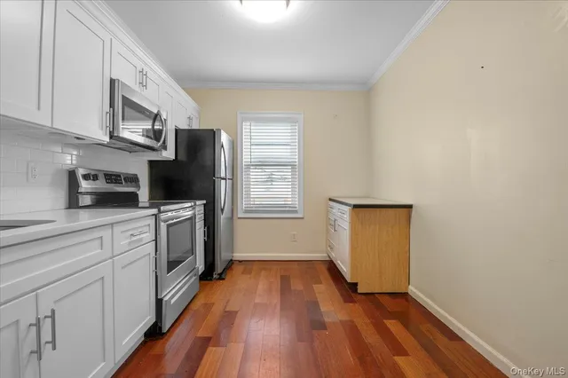 a kitchen with stainless steel appliances a stove top oven cabinets a refrigerator and wooden floor