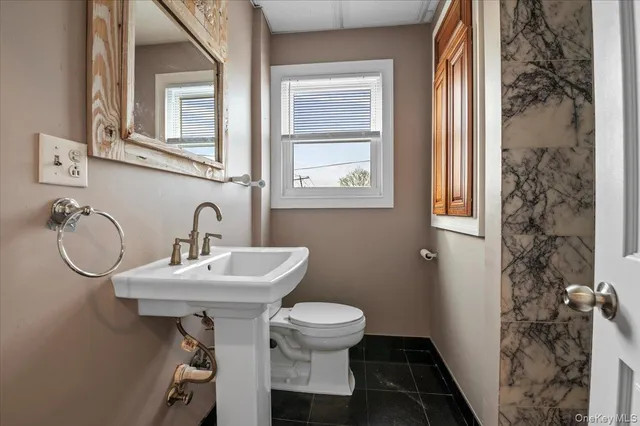 a bathroom with a sink toilet and a mirror