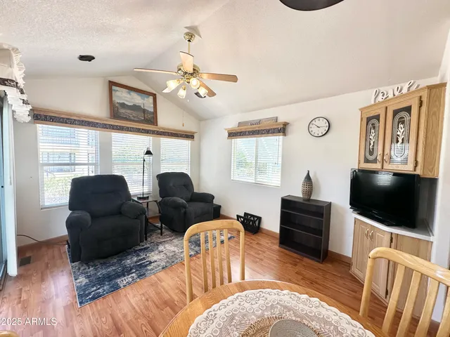 a living room with furniture a flat screen tv and kitchen view