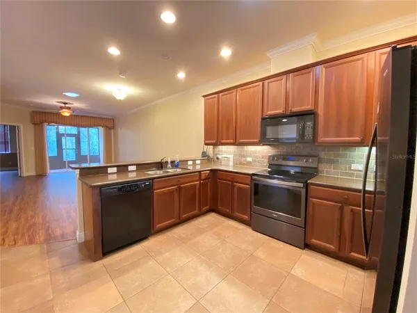 a kitchen with stainless steel appliances granite countertop a refrigerator stove and sink