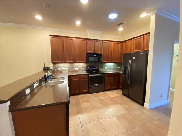 a kitchen with stainless steel appliances granite countertop a refrigerator a sink a stove a microwave and island