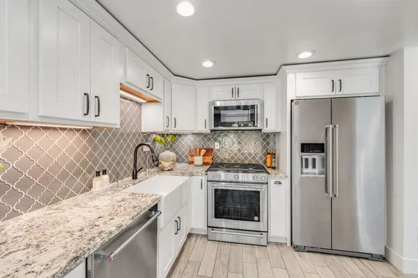 a kitchen with stainless steel appliances granite countertop a refrigerator sink and stove