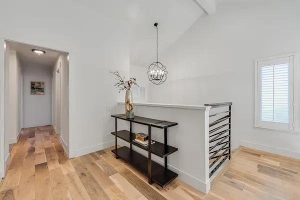 a view of a hallway with entryway wooden floor and front door