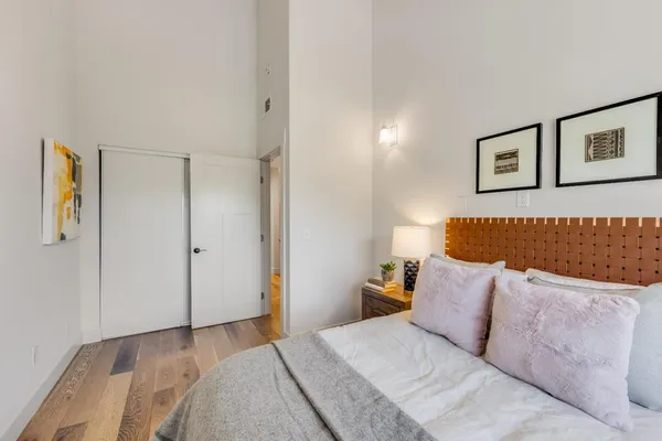 a bedroom with a bed and painting on the wall