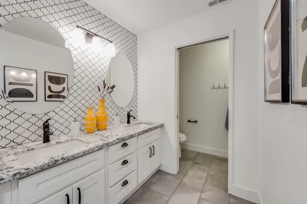 a bathroom with a granite countertop sink and a mirror