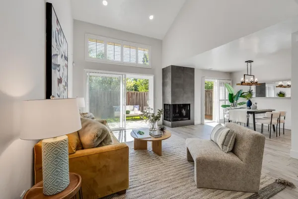 a living room with fireplace furniture and a large window
