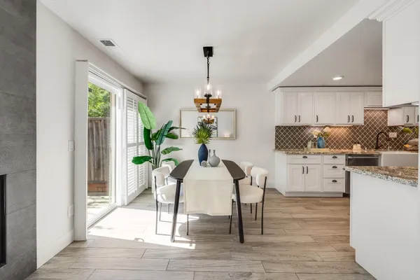 a dining room with furniture a chandelier and wooden floor