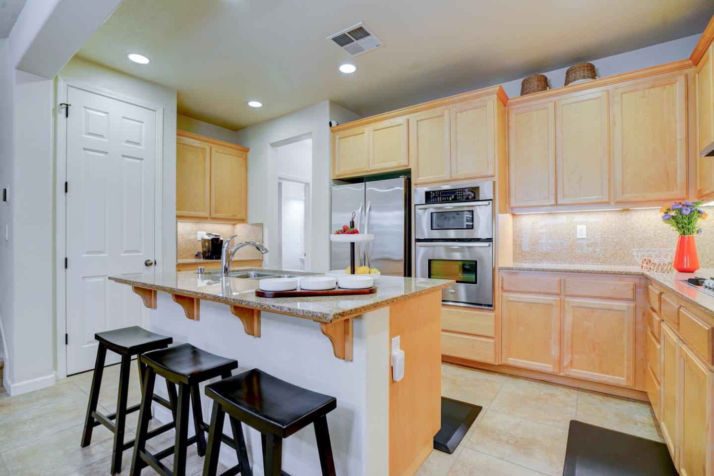 5236 Fioli Loop San Ramon, CA 94582 - Photo 13 of 40 a kitchen with stainless steel appliances granite countertop a table chairs sink and cabinets