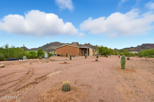 an aerial view of ocean and residential houses with outdoor space