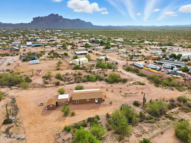 an aerial view of residential house with yard and mountain view in back