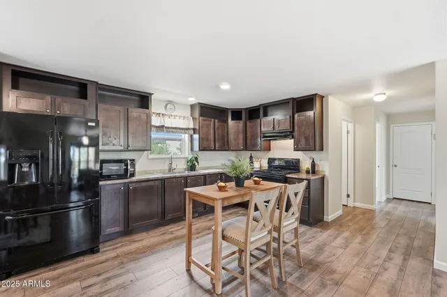 a kitchen with stainless steel appliances kitchen island granite countertop a stove refrigerator and cabinets