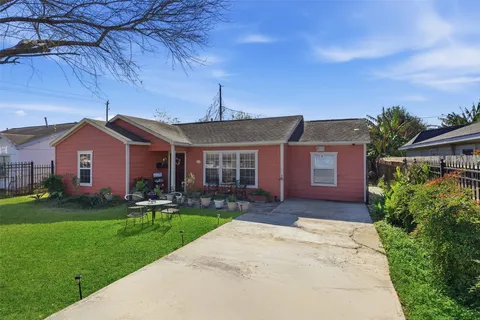 a front view of a house with a garden and yard