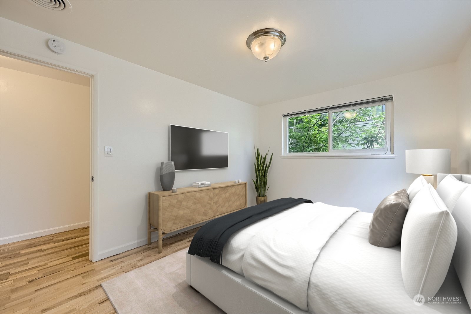 8536 Nesbit Avenue North, Unit A Seattle, WA 98103 - Photo 21 of 32 a bedroom with a large bed and a flat screen tv