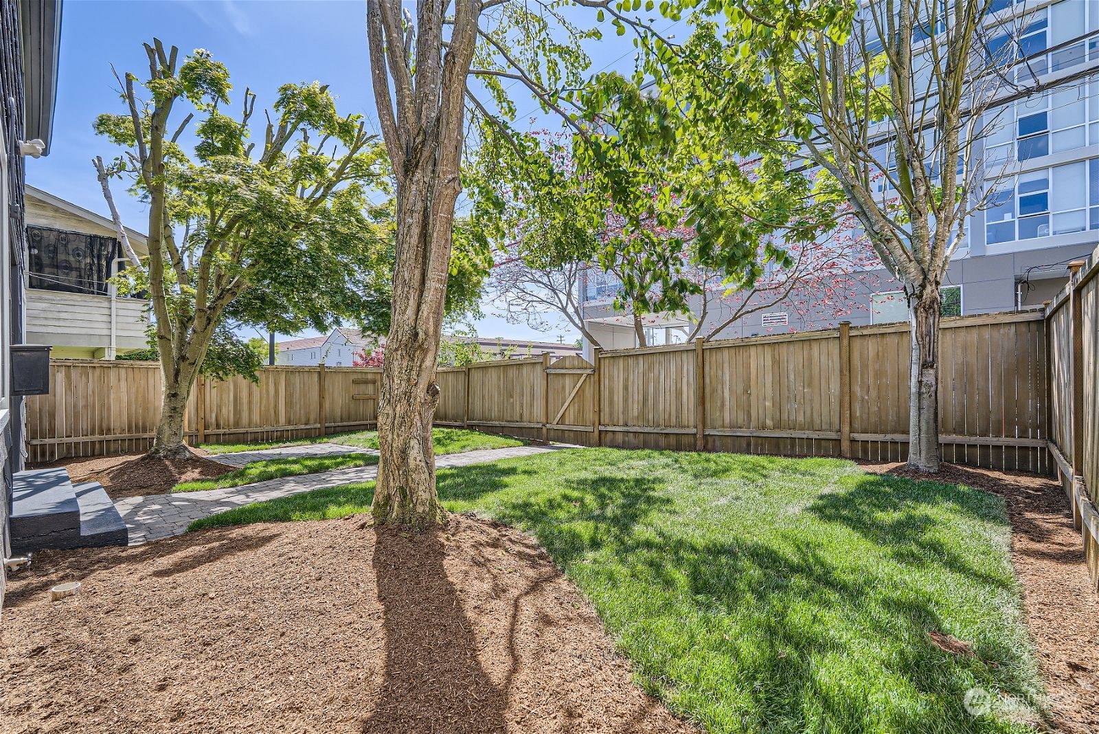 8536 Nesbit Avenue North, Unit A Seattle, WA 98103 - Photo 27 of 32 a view of a backyard with plants and wooden fence