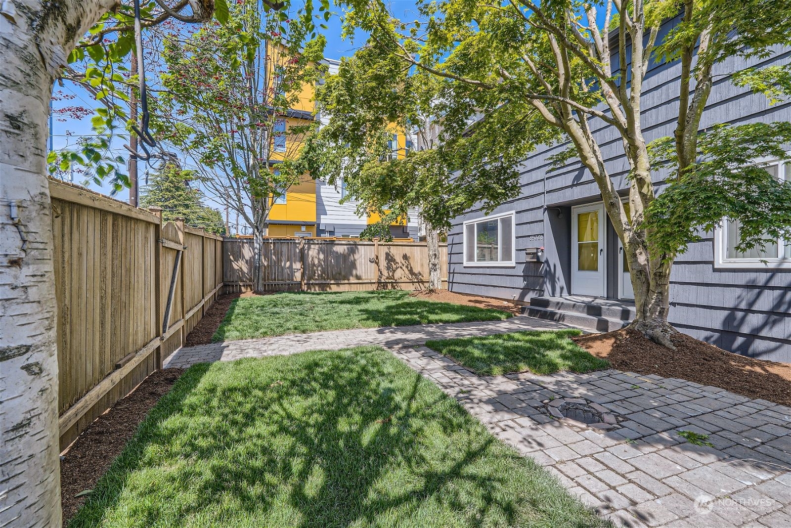 8536 Nesbit Avenue North, Unit A Seattle, WA 98103 - Photo 29 of 32 a view of a house with backyard and a tree