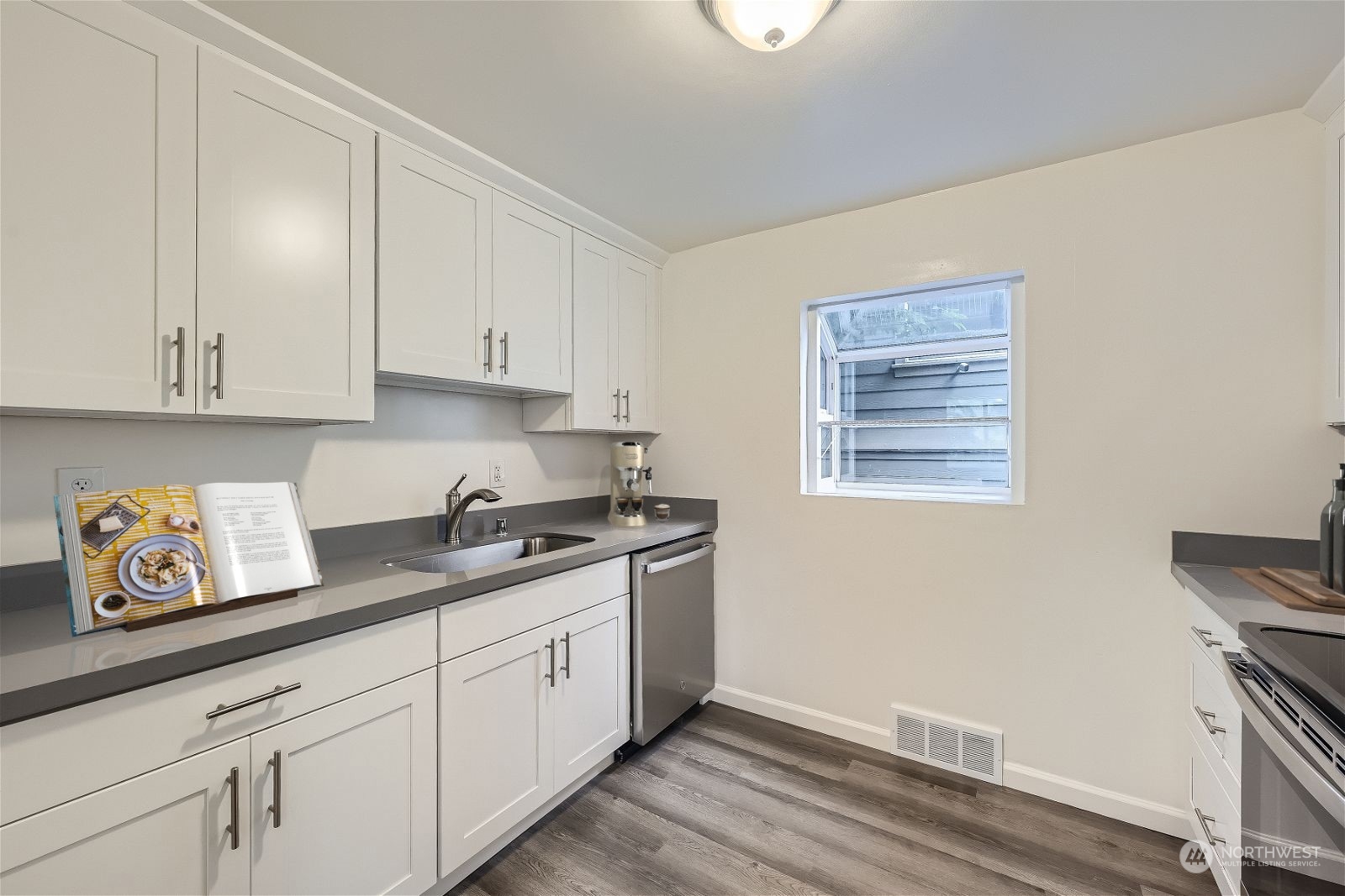 8536 Nesbit Avenue North, Unit A Seattle, WA 98103 - Photo 8 of 32 a kitchen with granite countertop a sink and a stove top oven