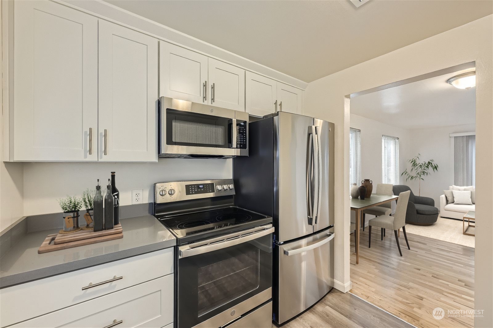 8536 Nesbit Avenue North, Unit A Seattle, WA 98103 - Photo 9 of 32 a kitchen with stainless steel appliances white cabinets granite counter tops and wooden floors