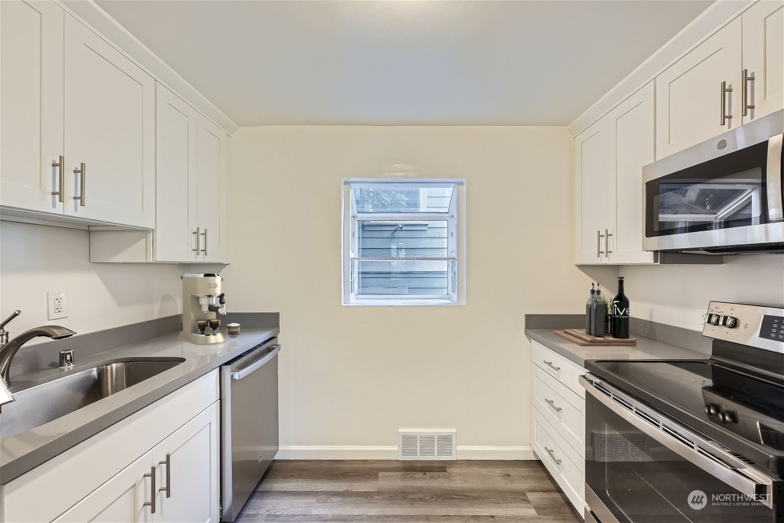 8536 Nesbit Avenue North, Unit A Seattle, WA 98103 - Photo 10 of 32 a kitchen with stainless steel appliances granite countertop a sink stove and cabinets