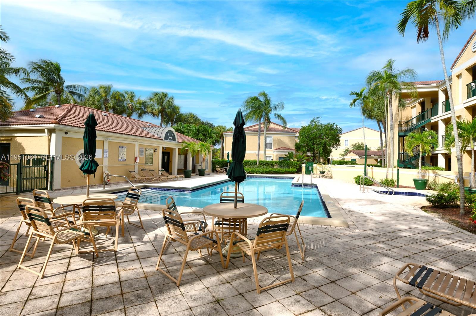 833 Riverside Drive, Unit 811 Coral Springs, FL 33071 - Photo 1 of 26 a view of a patio with a dining table and chairs with a fire pit
