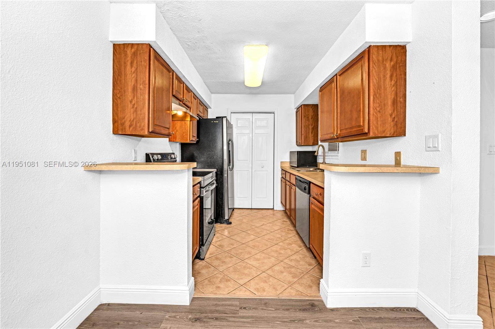 833 Riverside Drive, Unit 811 Coral Springs, FL 33071 - Photo 5 of 26 a kitchen with a sink and a refrigerator