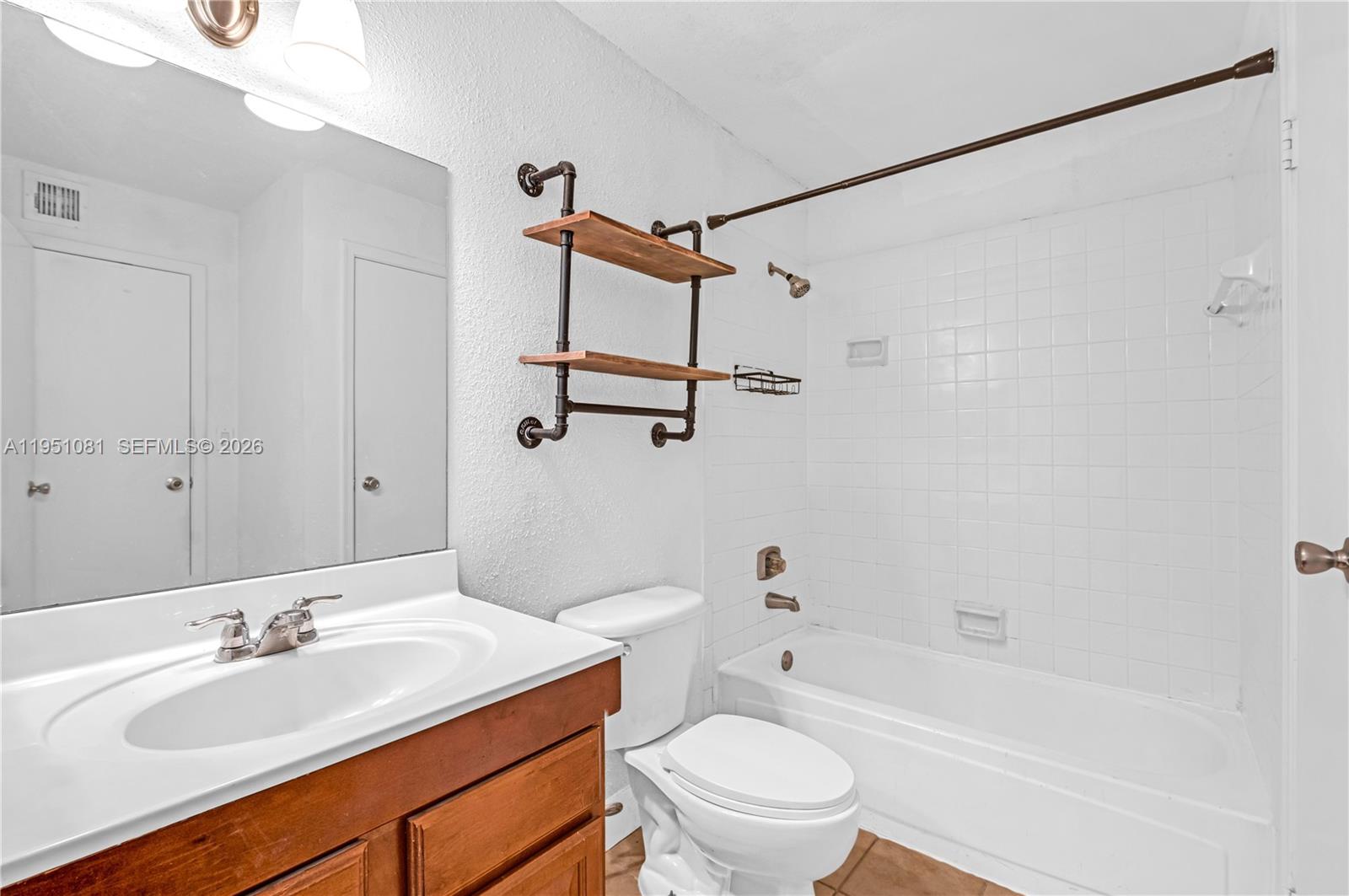833 Riverside Drive, Unit 811 Coral Springs, FL 33071 - Photo 8 of 26 a bathroom with a sink toilet tub vanity and shower