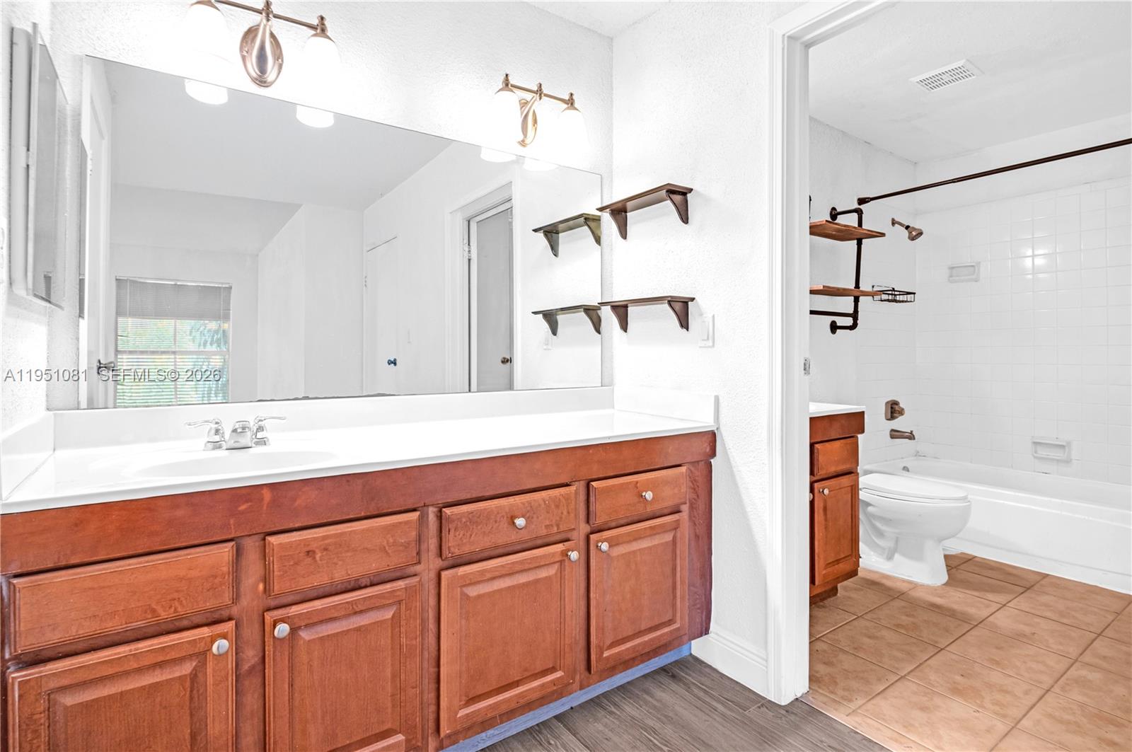 833 Riverside Drive, Unit 811 Coral Springs, FL 33071 - Photo 9 of 26 a spacious bathroom with a sink double vanity granite tub shower and a mirror
