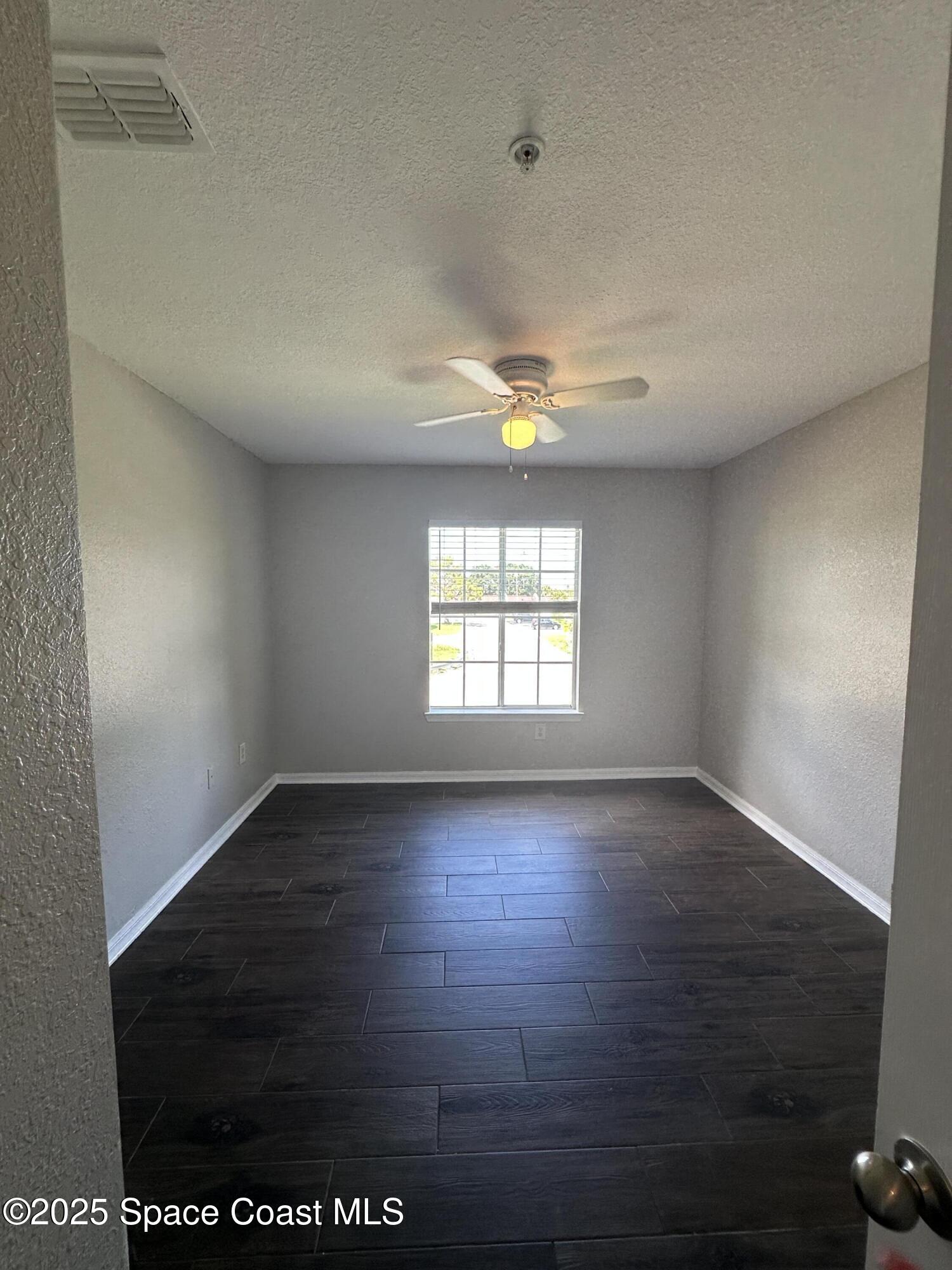 3511 D'Avinci Way, Unit 2012 Melbourne, FL 32901 - Photo 11 of 22 an empty room with wooden floor and windows