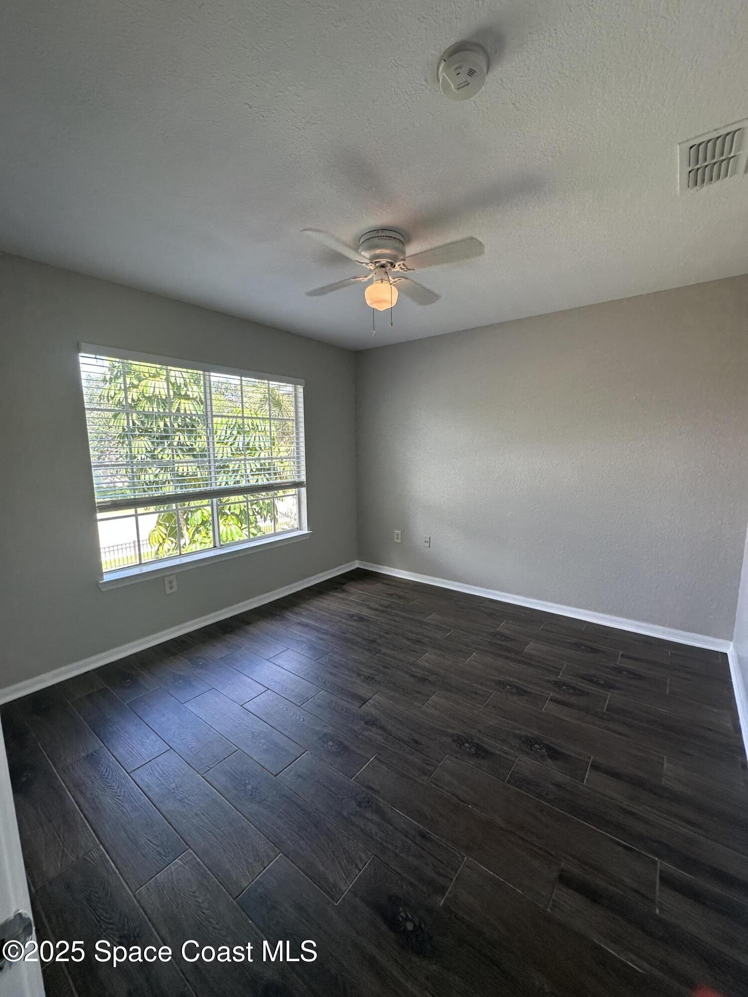 3511 D'Avinci Way, Unit 2012 Melbourne, FL 32901 - Photo 13 of 22 an empty room with wooden floor and windows