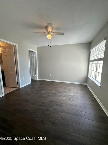 an empty room with wooden floor and window