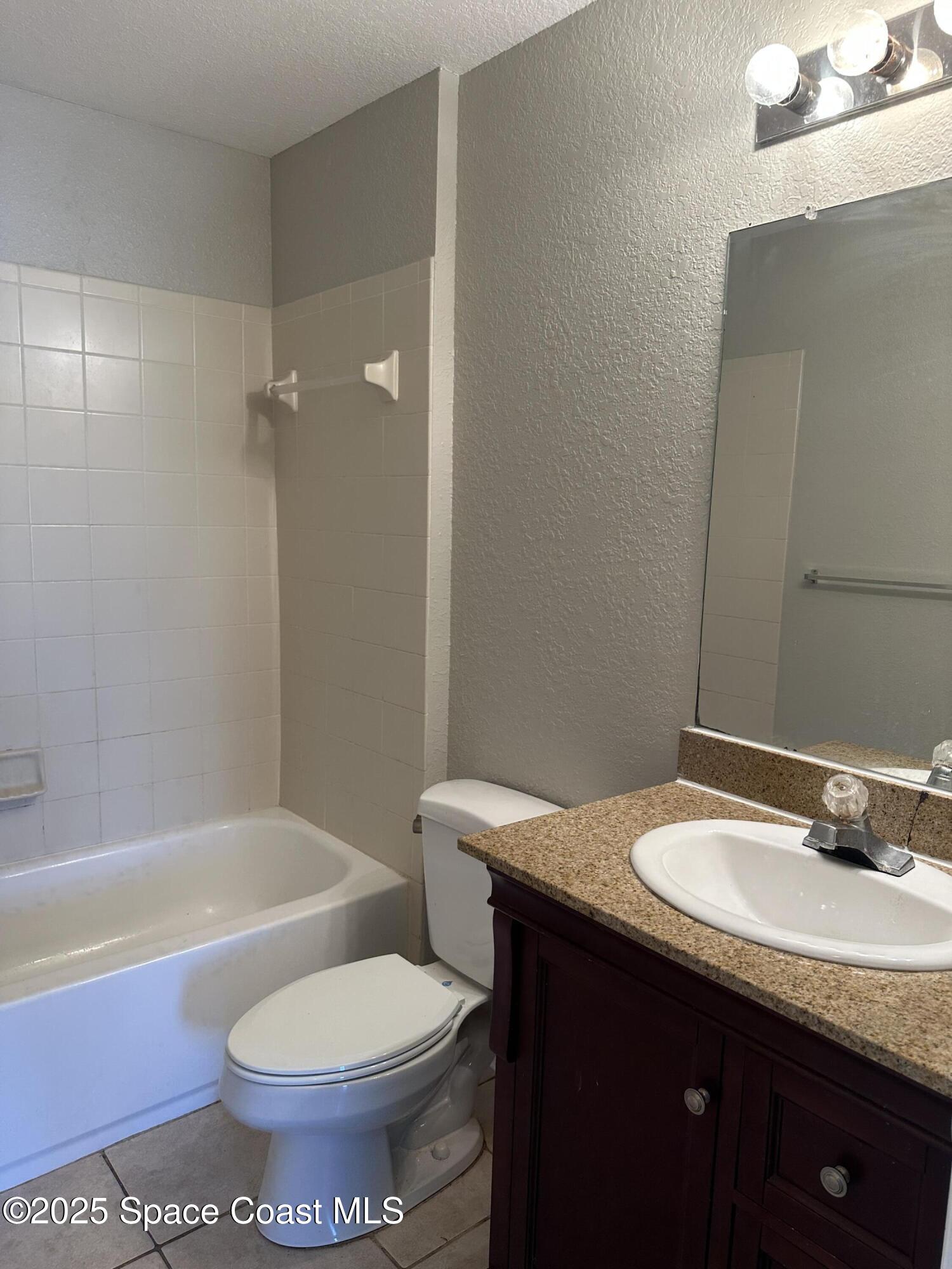 3511 D'Avinci Way, Unit 2012 Melbourne, FL 32901 - Photo 15 of 22 a bathroom with a granite countertop sink toilet and shower