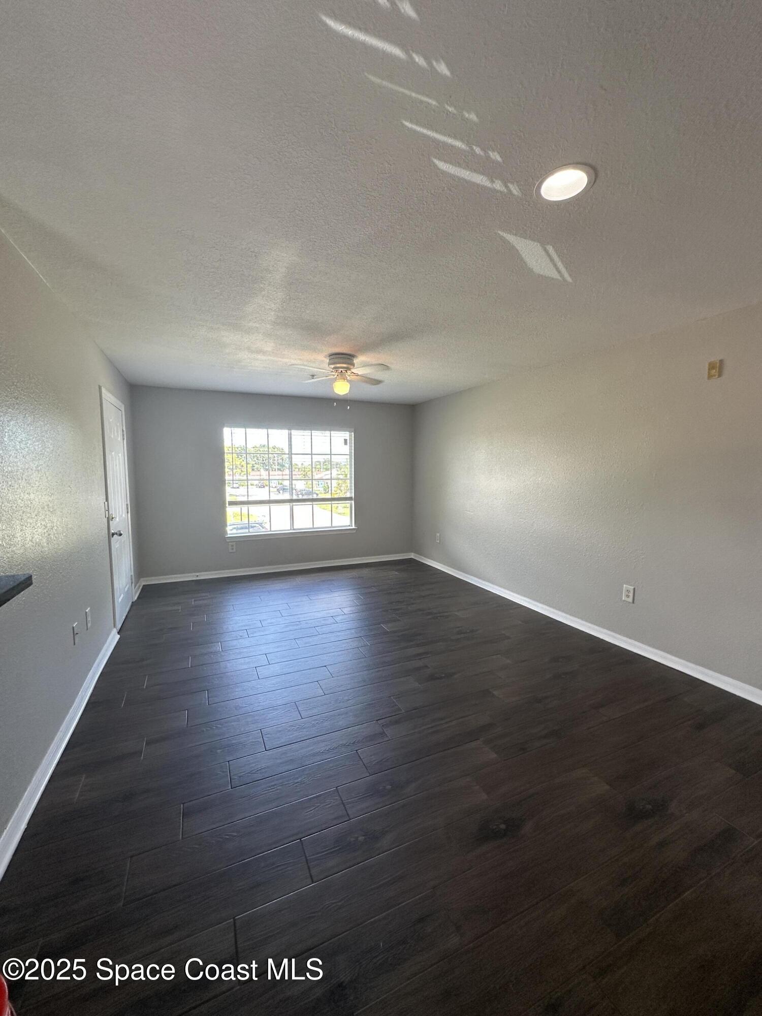 3511 D'Avinci Way, Unit 2012 Melbourne, FL 32901 - Photo 4 of 22 an empty room with wooden floor and windows