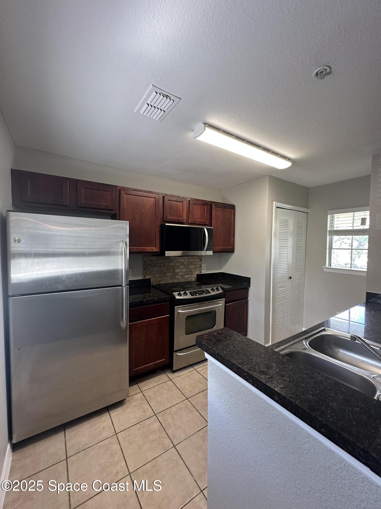 3511 D'Avinci Way, Unit 2012 Melbourne, FL 32901 - Photo 6 of 22 a kitchen with stainless steel appliances granite countertop a refrigerator and a stove