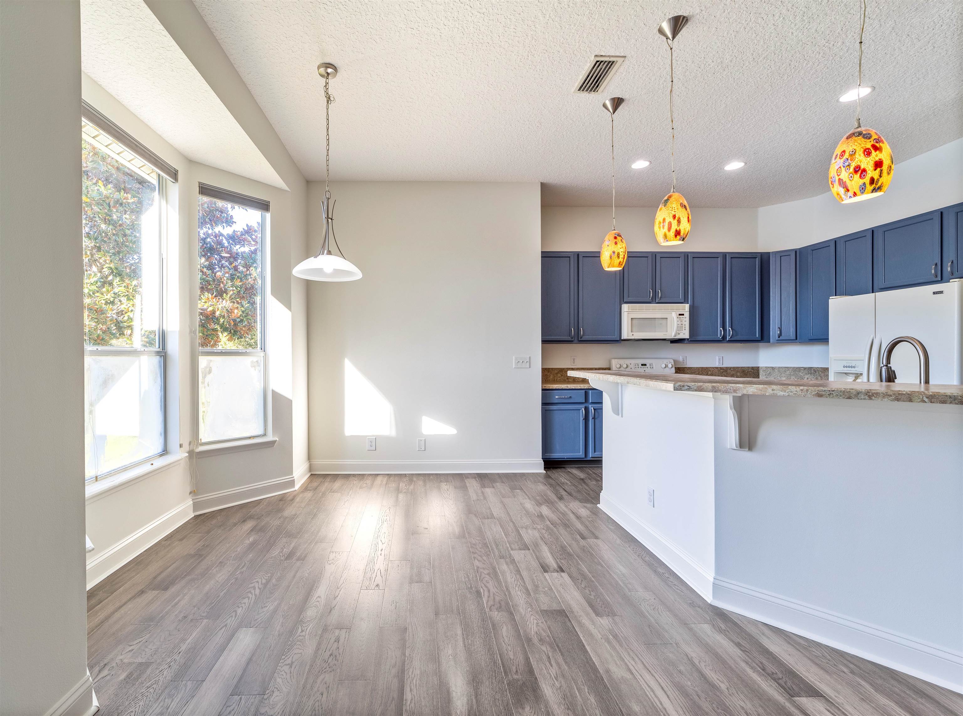 145 Whisper Ridge Drive St. Augustine, FL 32092 - Photo 13 of 32 a kitchen with a wooden floor window and a refrigerator