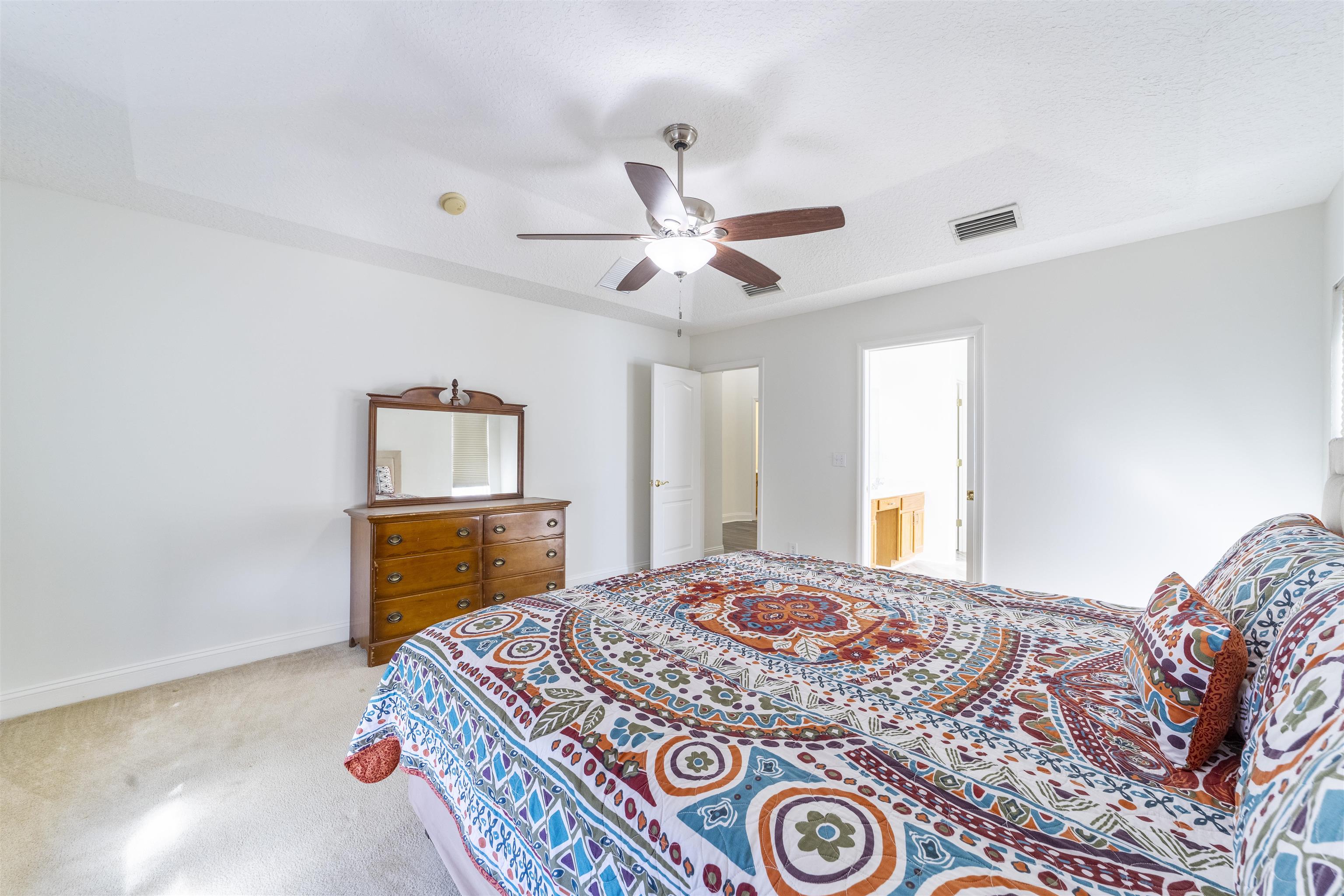 145 Whisper Ridge Drive St. Augustine, FL 32092 - Photo 21 of 32 a bedroom with a bed and a dresser