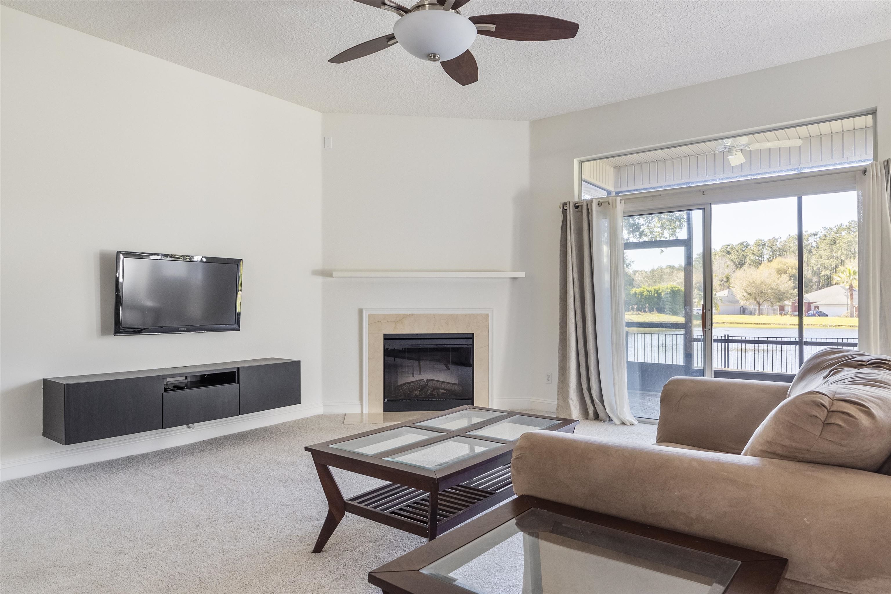 145 Whisper Ridge Drive St. Augustine, FL 32092 - Photo 10 of 32 a living room with furniture a flat screen tv and a fireplace