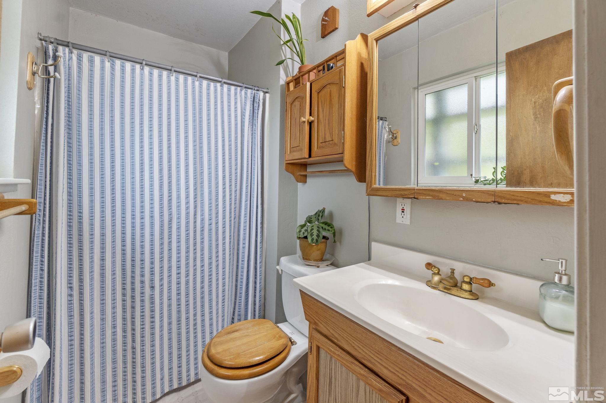 1480 Rayburn Drive Reno, NV 89503 - Photo 14 of 29 a bathroom with a sink a toilet and shower curtain