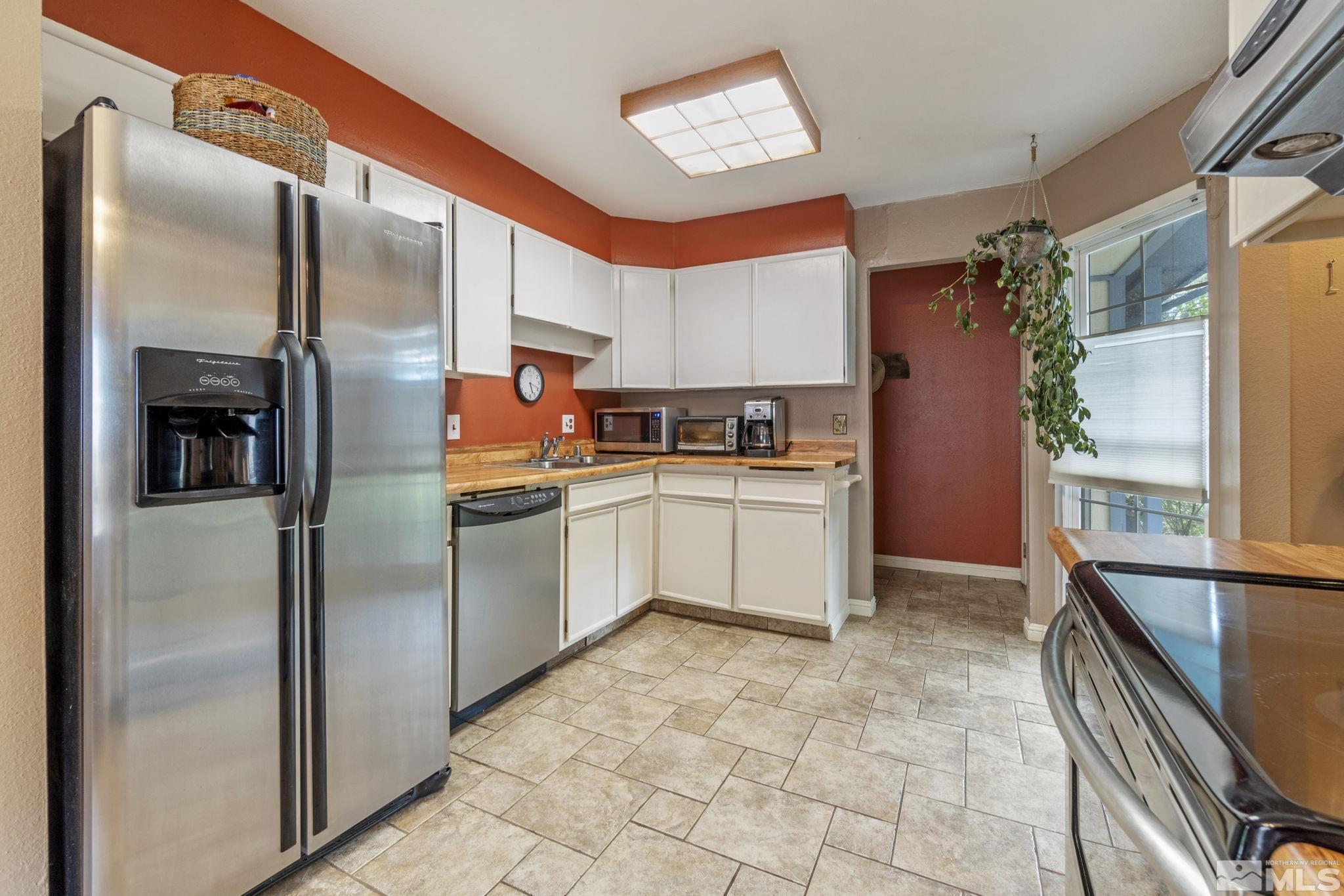 1480 Rayburn Drive Reno, NV 89503 - Photo 6 of 29 a kitchen with stainless steel appliances granite countertop a refrigerator a sink and white cabinets