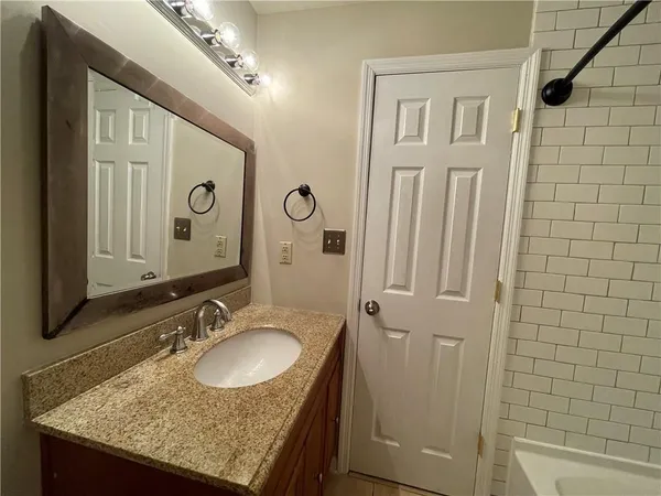 a bathroom with a granite countertop sink toilet and shower