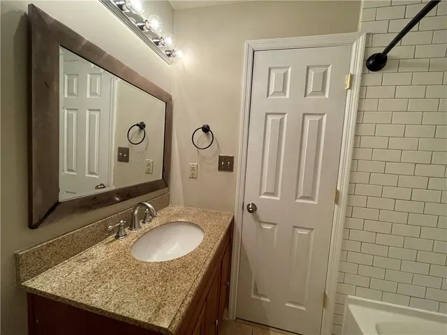 a bathroom with a granite countertop sink toilet and shower