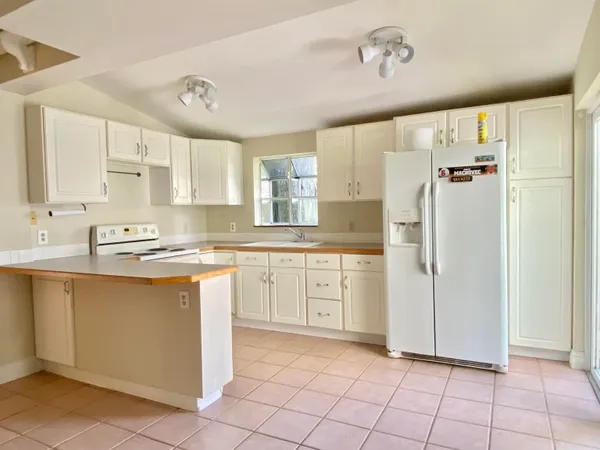 a kitchen with a refrigerator a sink and cabinets