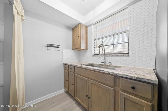 a kitchen with granite countertop cabinets sink and window