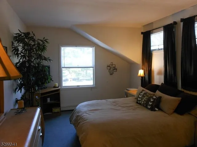a bedroom with a bed dresser and a window