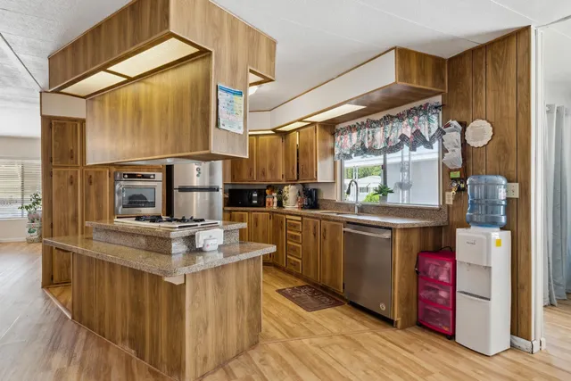a kitchen with stainless steel appliances granite countertop a sink and cabinets